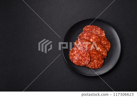 Delicious smoked pepperoni sausage sliced with salt, spices and herbs Delicious smoked pepperoni sausage sliced with salt, spices and herbs 117306623