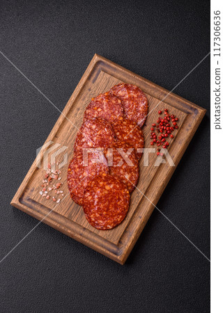 Delicious smoked pepperoni sausage sliced with salt, spices and herbs Delicious smoked pepperoni sausage sliced with salt, spices and herbs 117306636