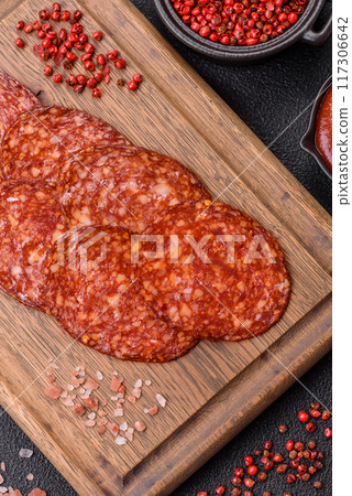 Delicious smoked pepperoni sausage sliced with salt, spices and herbs Delicious smoked pepperoni sausage sliced with salt, spices and herbs 117306642