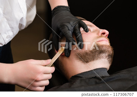 Ear hair wax removal. Hair removal procedure in barbershop. 117306707