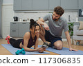 Training to become the best. Beautiful young woman and man in sports clothing exercising at home. 117306835