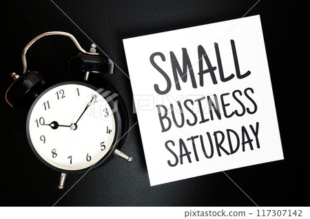 Small Business Saturday text with alarm clock on black background 117307142