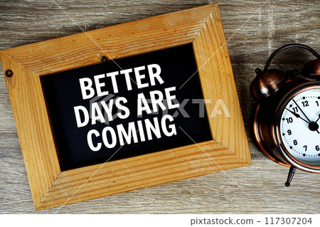 Better days are coming text on wooden board with alarm clock on wooden background Better days are coming text on wooden board with alarm clock on wooden background 117307204