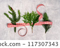 Red and white ribbon with three Christmas tree branches flat lay. Merry Christmas and Happy New Year seasons greetings card. Banner with copy space 117307343