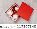 Red and white Christmas baubles in a box flat lay. Merry Christmas and Happy New Year seasons greetings card. Copy space. Festive border 117307345