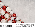 Red and white Christmas baubles in a box flat lay. Merry Christmas and Happy New Year seasons greetings card. Copy space. Festive border 117307347