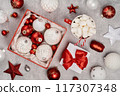 Red and white Christmas baubles in a box flat lay. Merry Christmas and Happy New Year seasons greetings card. Copy space. Festive full frame 117307348
