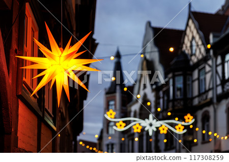 Charming Wernigerode town evening street view illuminated with Christmas lights garlands Herrnhutter stars on historical half-timbered houses facade. Twilight Festive city in Germany Charming Wernigerode town evening street view illuminated with Christmas lights garlands Herrnhutter stars on historical half-timbered houses facade. Twilight Festive city in Germany 117308259