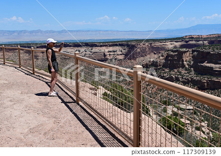 Woman photographing and enjoying scenery of Colorado National Monument. 117309139
