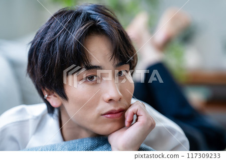 Young man lying on sofa 117309233