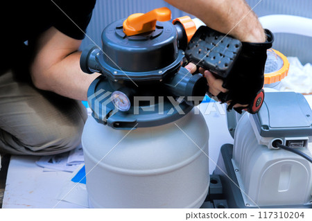 Maintenance worker service assembles sand filter system tank, equipment for swimming pool cleaning water 117310204