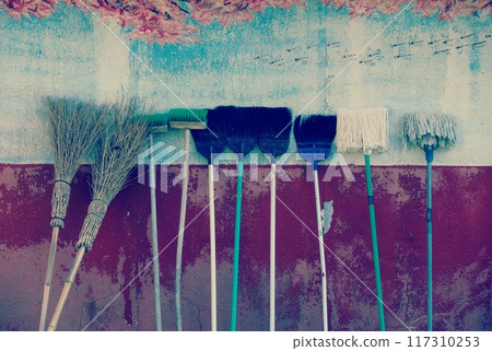 Cleaning tools lined up on the wall Cleaning tools lined up on the wall 117310253