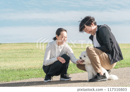 愛狗夫婦/家庭/家庭(中年/中年)在公園遛狗 愛狗夫婦/家庭/家庭(中年/中年)在公園遛狗 117310803