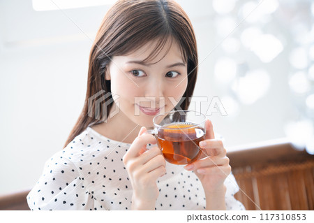 A feminine woman drinking tea A feminine woman drinking tea 117310853