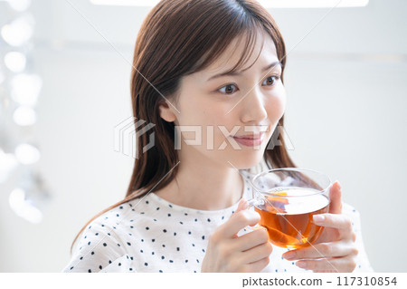 A feminine woman drinking tea A feminine woman drinking tea 117310854