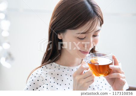 A feminine woman drinking tea 117310856