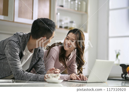 young asian couple using laptop computer together at home young asian couple using laptop computer together at home 117310920