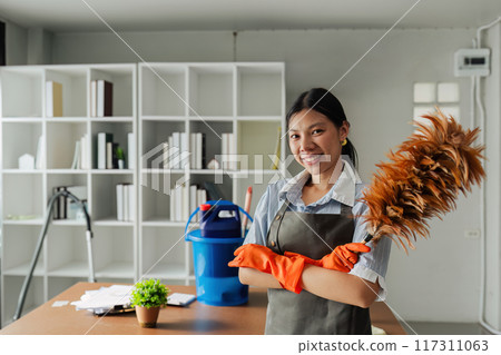Female housekeeper smile and wearing glove, preparing to clean office 117311063