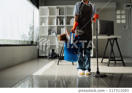 Female housekeeper smile and wearing glove, preparing to clean office Female housekeeper smile and wearing glove, preparing to clean office 117311083