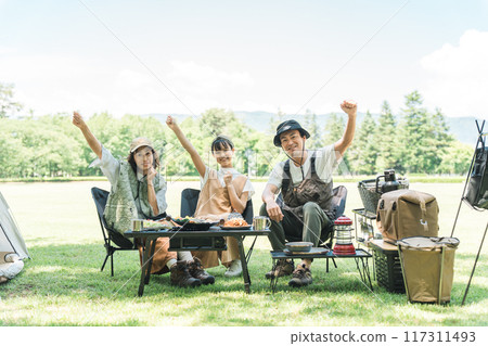 A friendly family enjoying day camping, camping and barbecues at a park or campsite A friendly family enjoying day camping, camping and barbecues at a park or campsite 117311493