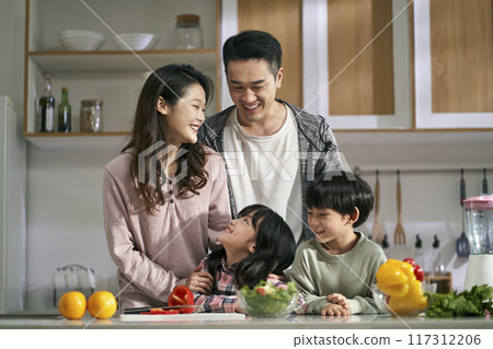 happy asian family with two children in kitchen at home happy asian family with two children in kitchen at home 117312206