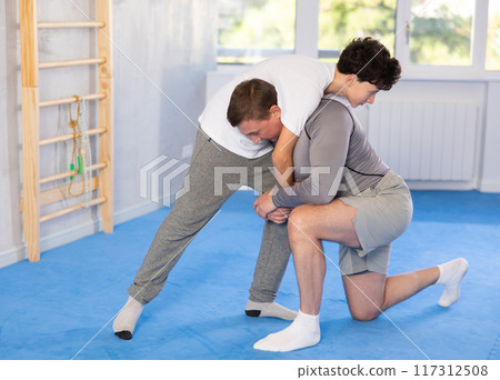 Personal training in gym - father teaching his teenage son self-defense techniques 117312508