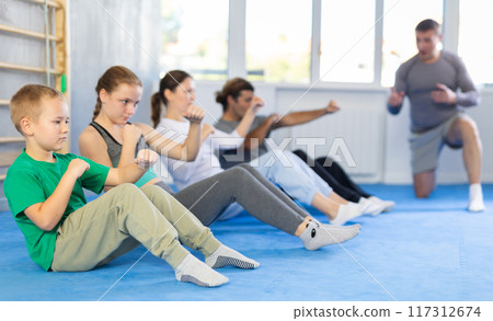 Family pupils performs exercises to strengthen press and improve accuracy of hands 117312674