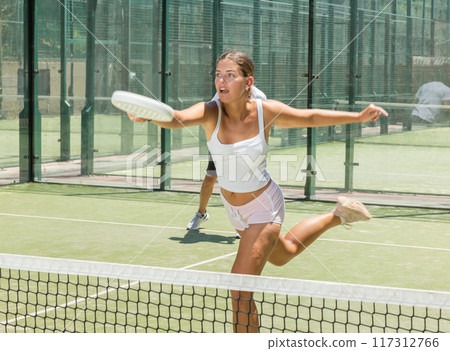 Young woman and man playing doubles padel Young woman and man playing doubles padel 117312766