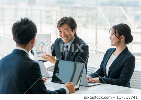 Smiling businessmen and businesswomen having a meeting or business negotiation in a corporate office Smiling businessmen and businesswomen having a meeting or business negotiation in a corporate office 117315741