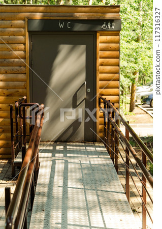 An accessible restroom is situated in a forested setting 117316327