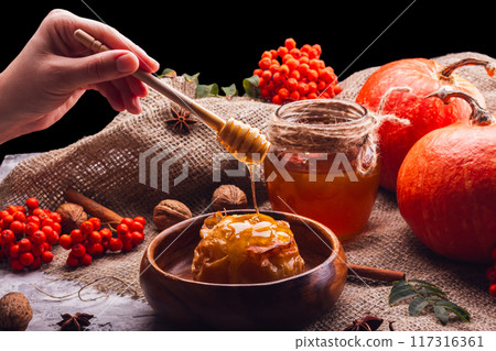 Still Life with Honey, Baked Apple and Pumpkins on a Black Background Still Life with Honey, Baked Apple and Pumpkins on a Black Background 117316361