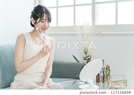 穿著家居服的年輕亞洲女性用面部按摩器按摩 穿著家居服的年輕亞洲女性用面部按摩器按摩 117316699