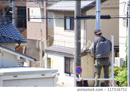 一名男子將安全攝影機安裝在室外燈上 117316752