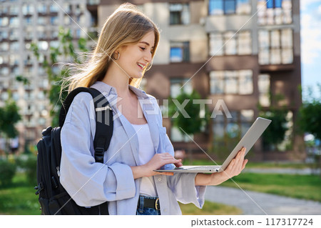 Young female college student using laptop computer outdoor Young female college student using laptop computer outdoor 117317724