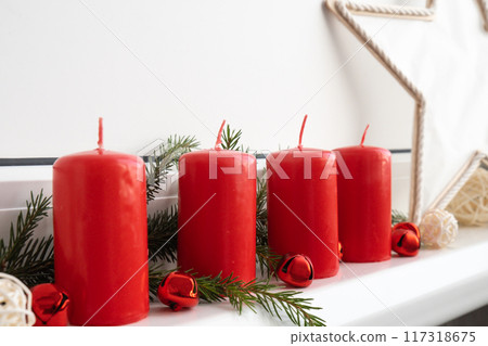 Four Advent red candles, fir branches and Christmas zero waste decorations in windowsill. Holiday preparation copy space for text. Catholic traditions of Christmas new year winter 117318675