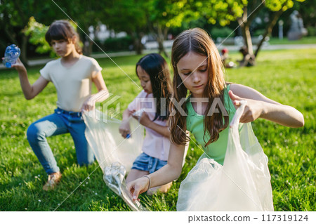 Students on nature walk picking plastic litter, environmental cleanup during outdoor sustainable education class. Concept of experiential learning and ecoliteracy. 117319124