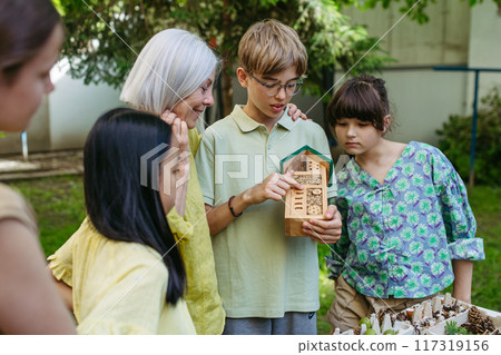 Insect hotel as educational tool for children in outdoor sustainable educational class. Young students learning about insect and biodiversity. 117319156