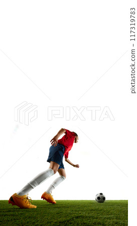 Low angle view of soccer athlete ready to kick ball in motion aiming to opponents gates on green grass against white background. 117319783