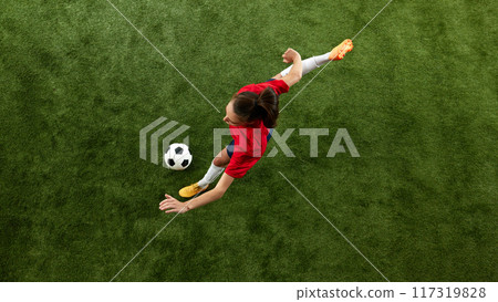Focused on game female soccer player passing ball in motion during training session on green lash stadium. Focused on game female soccer player passing ball in motion during training session on green lash stadium. 117319828