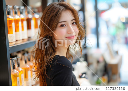 A beautiful woman wearing a black dress shopping at an aroma oil store 117320138