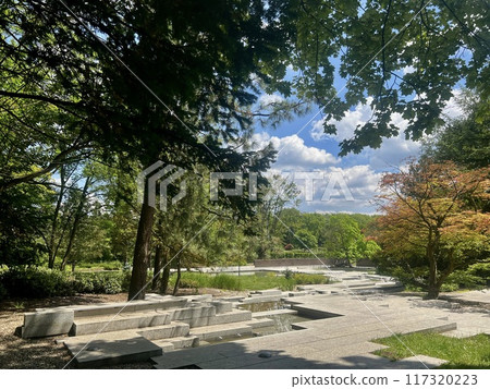 Garden with stone walkway and fountain in the park on sunny day at Chorzow, Poland 117320223