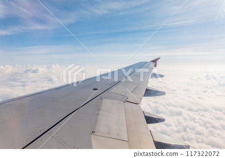 View from the airplane window at a beautiful cloudy sky and the airplane wing View from the airplane window at a beautiful cloudy sky and the airplane wing 117322072