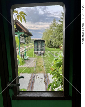 Railway station view through the window of a train in the countryside 117322353