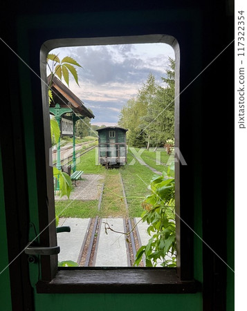 Railway station view through the window of a train in the countryside 117322354
