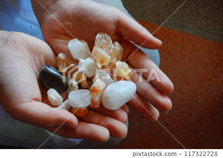 Many small natural stones in a child's palm Many small natural stones in a child's palm 117322728