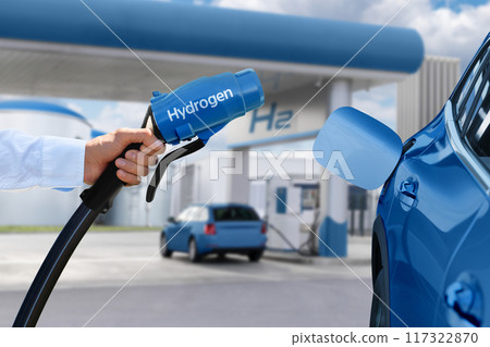 Man holds a hydrogen fueling nozzle. Refueling car with hydrogen fuel Man holds a hydrogen fueling nozzle. Refueling car with hydrogen fuel 117322870