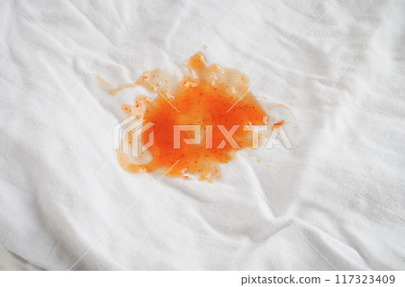 Dirty tomato sauce stain or ketchup on cloth to wash with washing powder, cleaning housework concept. Dirty tomato sauce stain or ketchup on cloth to wash with washing powder, cleaning housework concept. 117323409