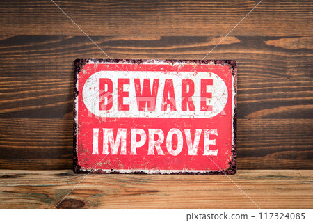 Improve. Beware sign with text on a wooden texture office table Improve. Beware sign with text on a wooden texture office table 117324085