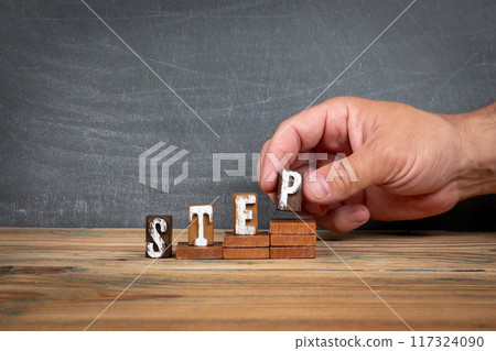 STEP. Wooden letters, alphabet blocks on steps. development and growth concept STEP. Wooden letters, alphabet blocks on steps. development and growth concept 117324090