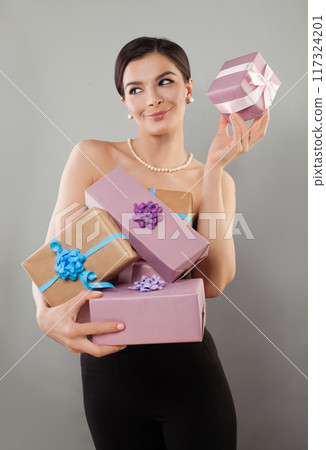 Gorgeous positive young adult model woman posing showing pink and beige present gift box Gorgeous positive young adult model woman posing showing pink and beige present gift box 117324201